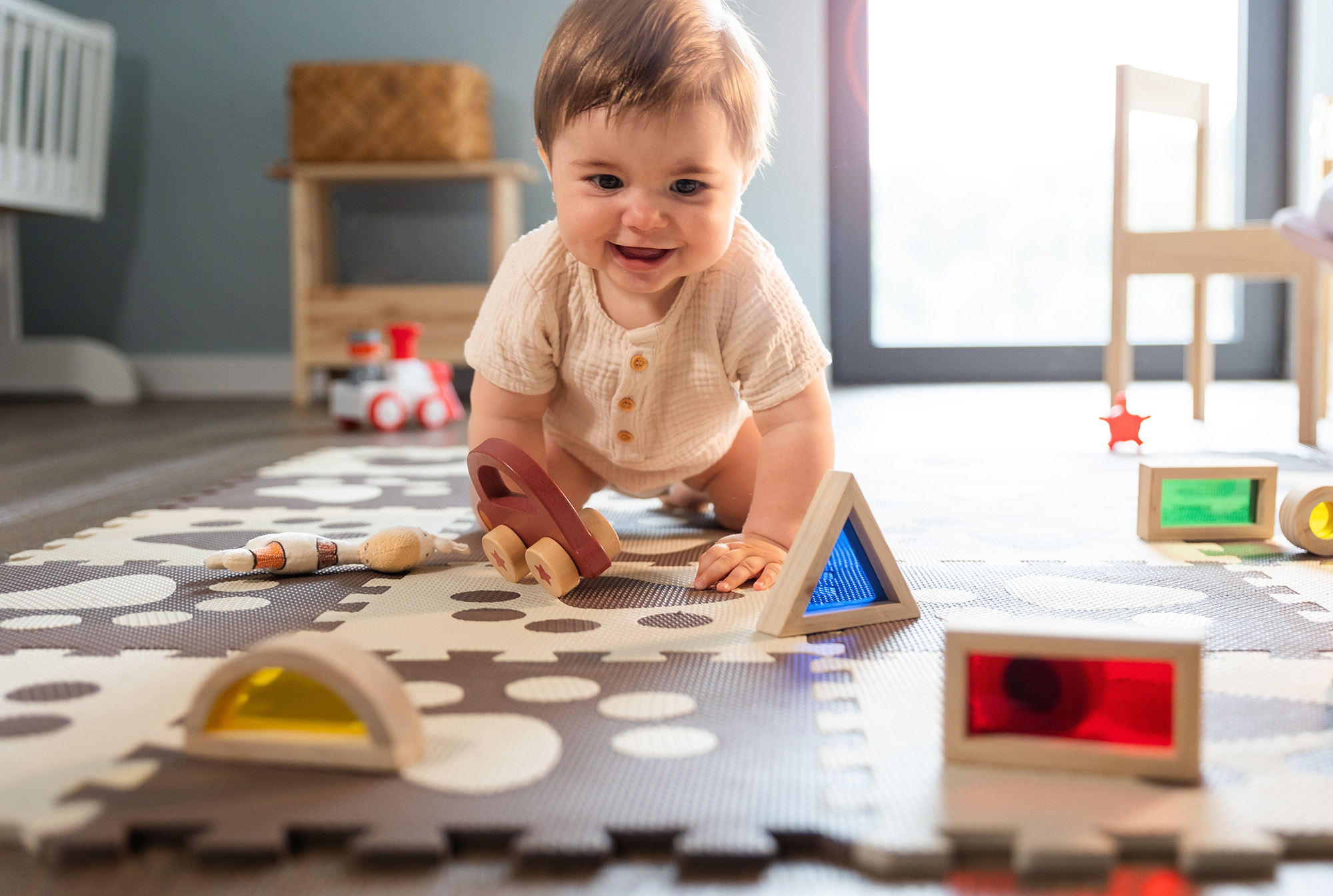 Infant Development Coaching Icon - Baby crawling amongst toys